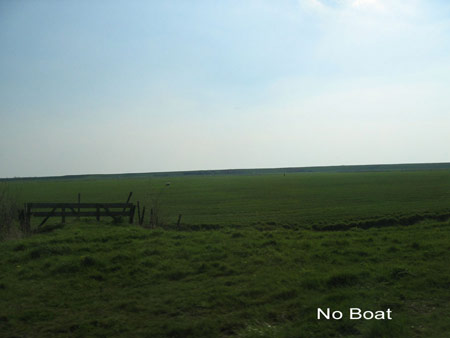 a gate, a green meadow behind and a far away dike_title: no boat